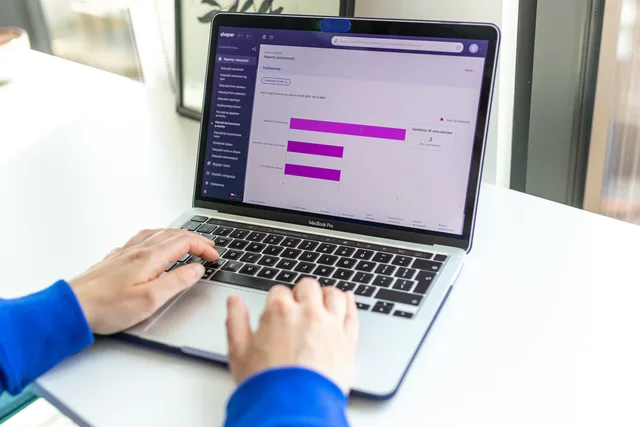 Person working on a laptop with business analytics displayed on the screen. Fastlæg et relevant attributionsvindue