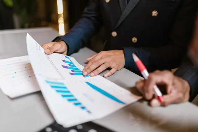 Close-up of professionals reviewing financial graphs at a business meeting. Mål fælles resultater uden dobbelttælling